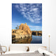 Rock island in a lake with blue sky and clouds Wall Mural