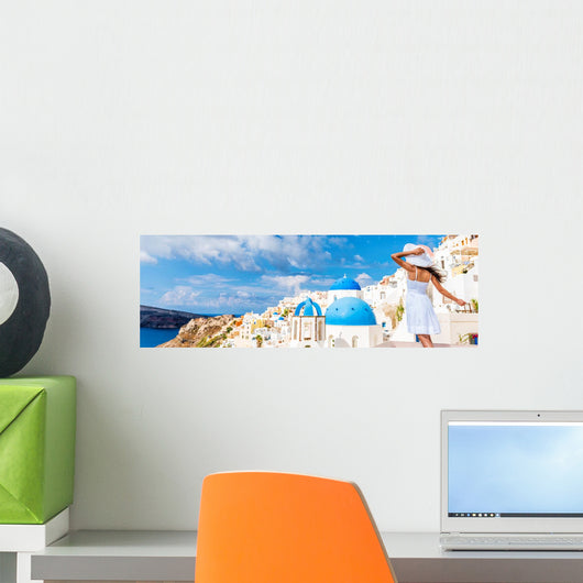 Europe tourist travel woman panorama banner from Oia, Santorini, Greece. Happy young woman looking at famous blue dome church landmark destination. Beautiful girl visiting the Greek islands. Wall Mural