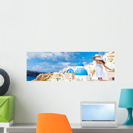 Europe tourist travel woman panorama banner from Oia, Santorini, Greece. Happy young woman looking at famous blue dome church landmark destination. Beautiful girl visiting the Greek islands. Wall Mural