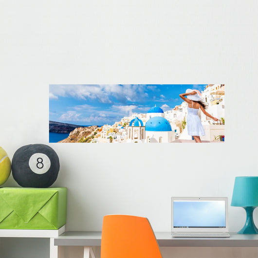Europe tourist travel woman panorama banner from Oia, Santorini, Greece. Happy young woman looking at famous blue dome church landmark destination. Beautiful girl visiting the Greek islands. Wall Mural