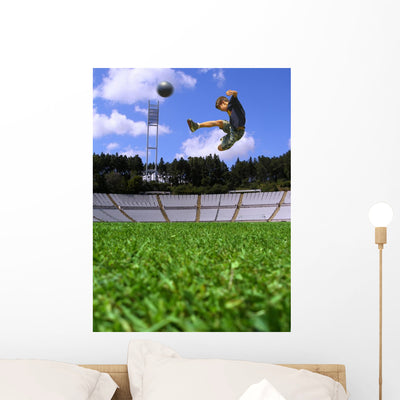 Boy Playing Soccer Wall Mural shown on a wall