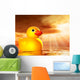 Rubber duckling in evening sunshine on the sea Wall Mural