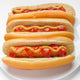 three classic hotdogs with mustard and ketchup on a plate Wall Mural