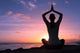 Young healthy woman practicing yoga on the beach at sunset

 Wall Mural