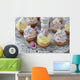 Purple and yellow cupcakes with sugared edible flowers on vintage cake stand Wall Mural