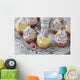Purple and yellow cupcakes with sugared edible flowers on vintage cake stand Wall Mural