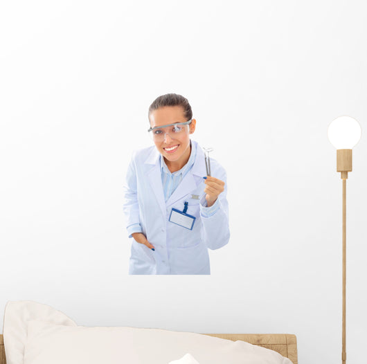A young dentist with a tool on a white background Wall Decal