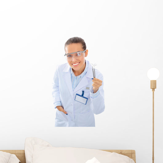 A young dentist with a tool on a white background Wall Decal