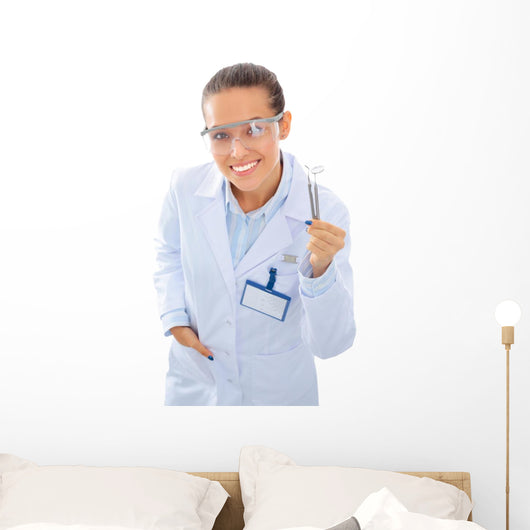 A young dentist with a tool on a white background Wall Decal