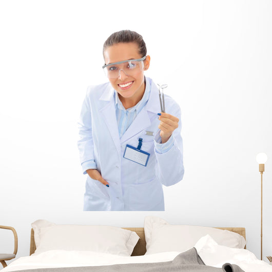 A young dentist with a tool on a white background Wall Decal