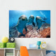 three dolphins close up portrait underwater while looking at you Wall Mural