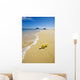 plumeria blossoms lie on white sand by the tropical pacific Wall Mural
