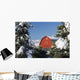 Snow covered red barn, evergreens, mountains Wall Mural