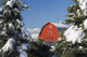 Snow covered red barn, evergreens, mountains Wall Mural
