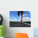Rear view of man running and jumping down a path on blue sky day Wall Mural