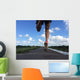 Rear view of man running and jumping down a path on blue sky day Wall Mural