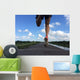 Rear view of man running and jumping down a path on blue sky day Wall Mural