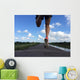 Rear view of man running and jumping down a path on blue sky day Wall Mural