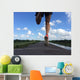 Rear view of man running and jumping down a path on blue sky day Wall Mural