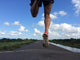 Rear view of man running and jumping down a path on blue sky day Wall Mural