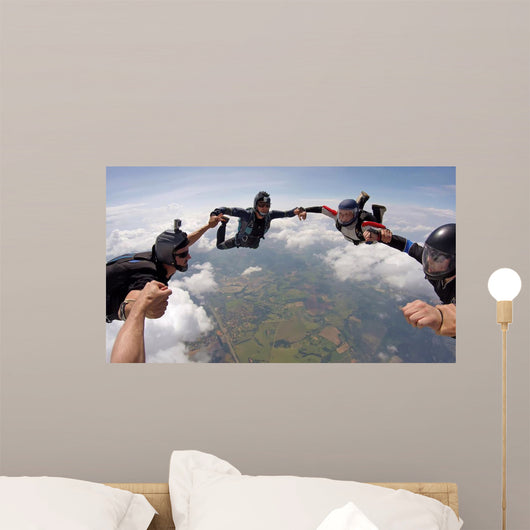 A group of friends holding hands teamwork skydiving Wall Mural