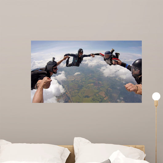 A group of friends holding hands teamwork skydiving Wall Mural