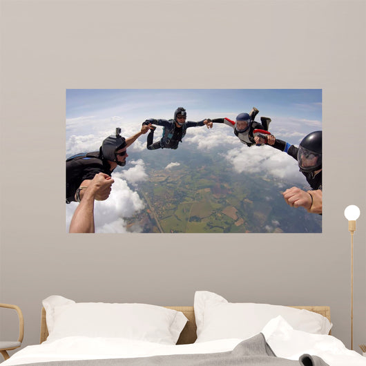 A group of friends holding hands teamwork skydiving Wall Mural