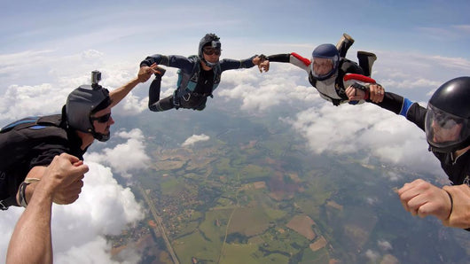 A group of friends holding hands teamwork skydiving Wall Mural
