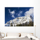Snow covered mountain peak, blue sky, clouds Wall Mural