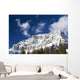 Snow covered mountain peak, blue sky, clouds Wall Mural