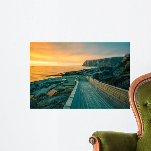 Senja island at orange sunset. Wooden pathway on the rocky beach Wall Mural