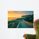 Senja island at orange sunset. Wooden pathway on the rocky beach Wall Mural