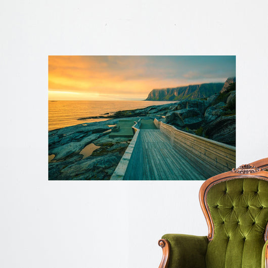 Senja island at orange sunset. Wooden pathway on the rocky beach Wall Mural