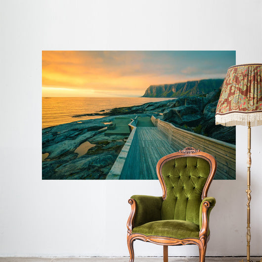 Senja island at orange sunset. Wooden pathway on the rocky beach Wall Mural