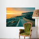 Senja island at orange sunset. Wooden pathway on the rocky beach Wall Mural