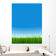 green grass over a clear blue sky without clouds as background Wall Mural