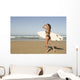 Young woman with surfboard on beach Wall Mural