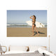 Young woman with surfboard on beach Wall Mural