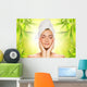 Beautiful young woman applying organic cosmetics to her skin Wall Mural