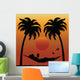 Woman Reading in a Hammock Between Palm Trees Wall Mural