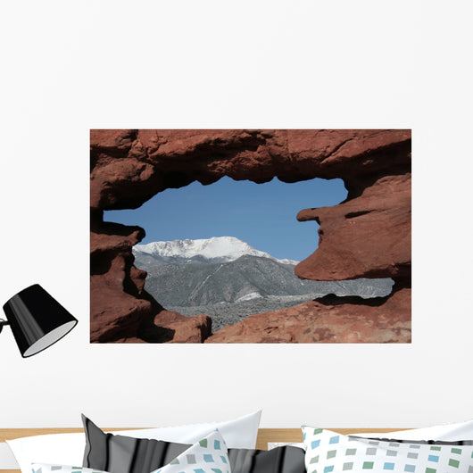 Pikes Peak mountain as seen through a hole in red rocks at Garde Wall Mural