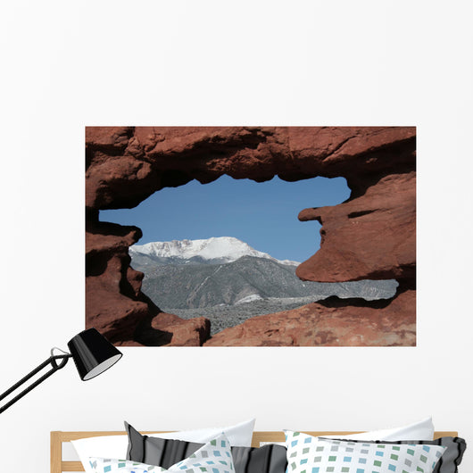 Pikes Peak mountain as seen through a hole in red rocks at Garde Wall Mural
