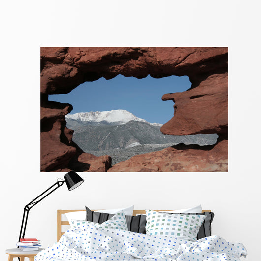 Pikes Peak mountain as seen through a hole in red rocks at Garde Wall Mural