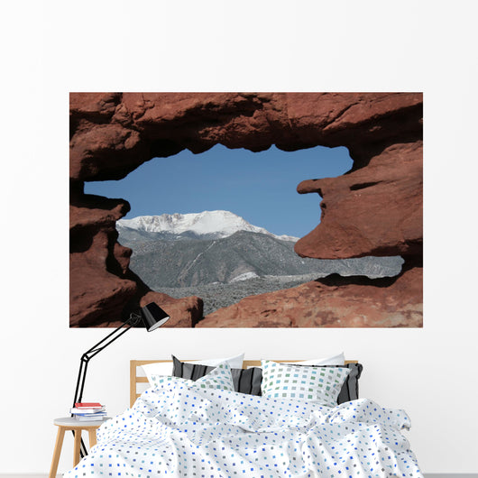 Pikes Peak mountain as seen through a hole in red rocks at Garde Wall Mural