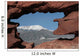 Pikes Peak mountain as seen through a hole in red rocks at Garde Wall Mural