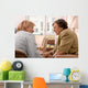 Senior woman is visited  by her doctor or caregiver at home Wall Mural