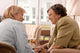 Senior woman is visited  by her doctor or caregiver at home Wall Mural