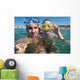 Lovely couple enjoying snorkeling during their vacation Wall Mural