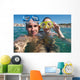 Lovely couple enjoying snorkeling during their vacation Wall Mural