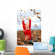 happy seven year old girl playing in pile of leave Wall Mural